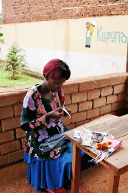 Kvinde fremstiller smykker i AIDS-projek